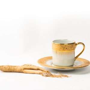 Cup of ginseng tea with a whole ginseng root