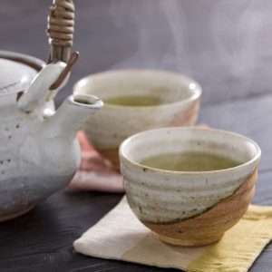 Chinese herbal tea served in ceramic cups with a teapot