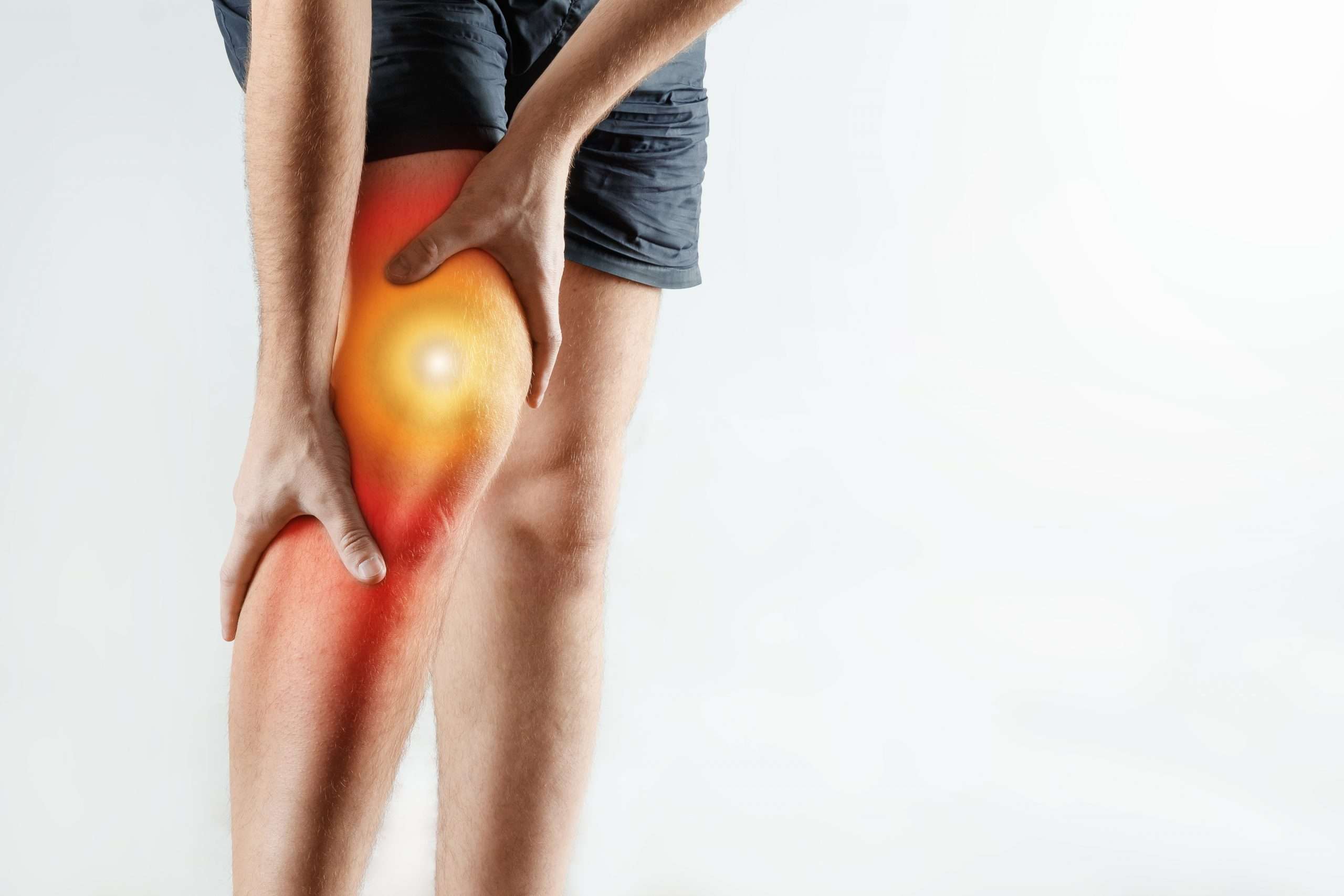 Person holding a sore knee, highlighting tendon and ligament pain